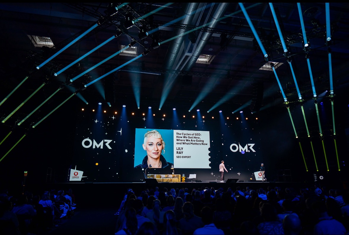 Lily Ray on stage at MozCon, speaking about SEO trends and AI